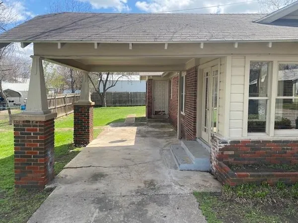 a view of a porch with a floor to ceiling window and front door