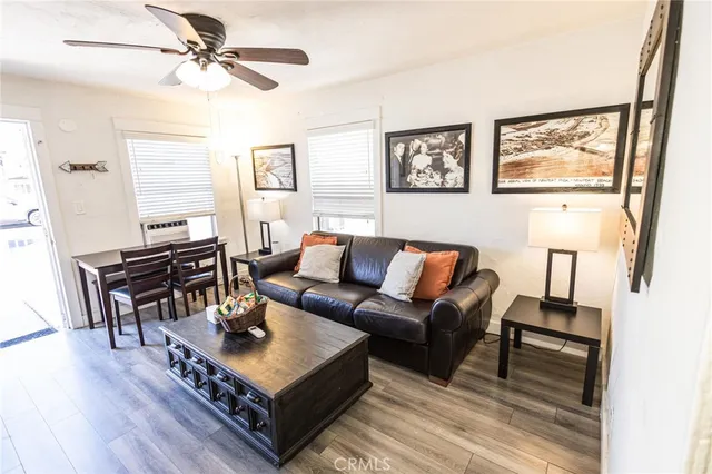 a living room with furniture a flat screen tv and a table