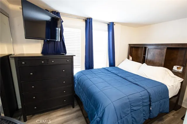 a bedroom with a large bed and flat tv screen