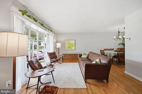 a living room with furniture a desk and chair with wooden floor