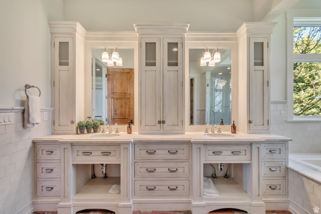 2579 Splendor Valley Road Kamas, UT 84036 - Photo 51 of 87 Bathroom featuring double vanity, suspended lighting, tile walls, a garden tub, and a wainscoted wall