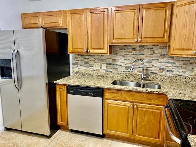 a kitchen with granite countertop cabinets and refrigerator