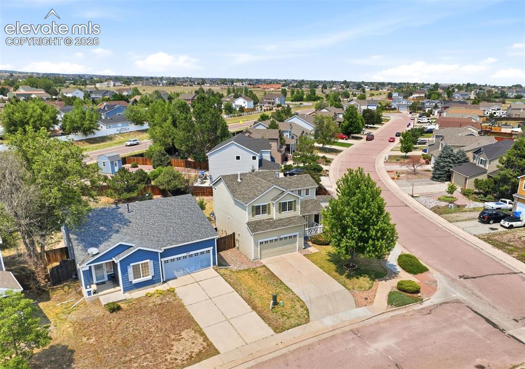 7904 Coffee Road Peyton, CO 80831 - Photo 44 of 48 Blue exterior with white trim, a covered porch, and a two-car garage
