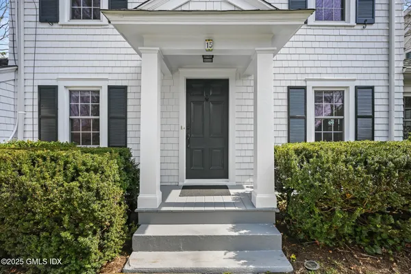 a front view of a house with a garden