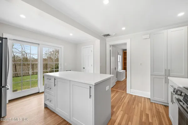 a view of a kitchen with a fridge and wooden floor