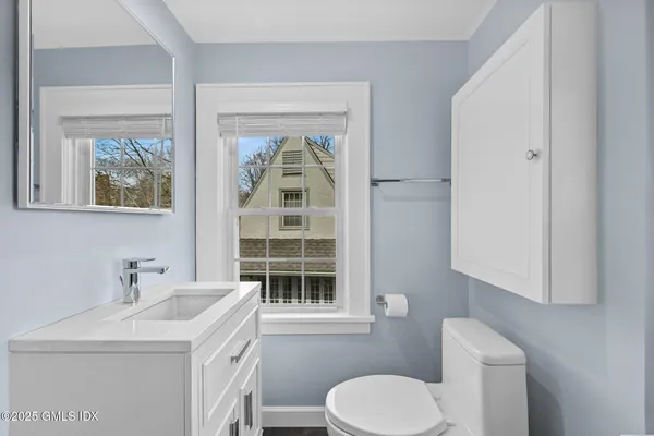 a bathroom with a sink toilet and window
