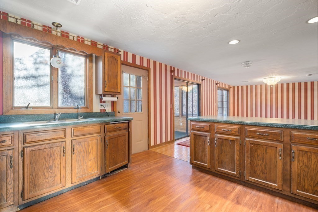 18 St Cloud Avenue Needham, MA 02492 - Photo 8 of 25 a large kitchen with kitchen island granite countertop a stove a sink and white cabinets with wooden floor
