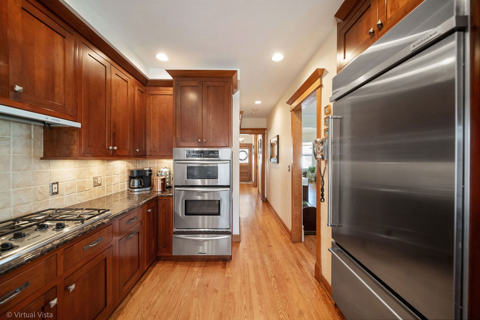 253 Olmsted Road Riverside, IL 60546 - Photo 14 of 36 a kitchen with stainless steel appliances and wooden cabinets