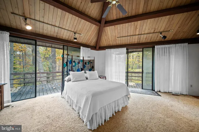 a large bed sitting in a bedroom next to a window