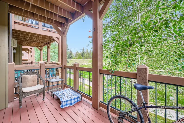 a balcony with wooden floor table and chairs
