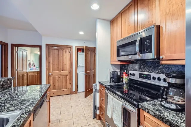 a kitchen with stainless steel appliances granite countertop a stove microwave and refrigerator