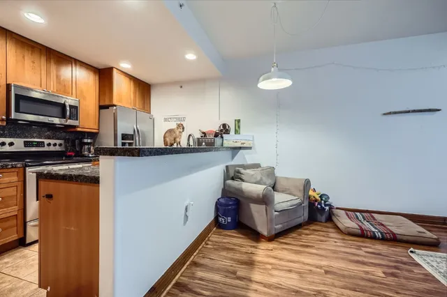 a living room with furniture kitchen and a flat screen tv