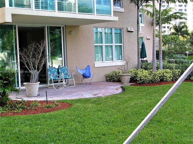 a view of a chair and table in back yard of the house