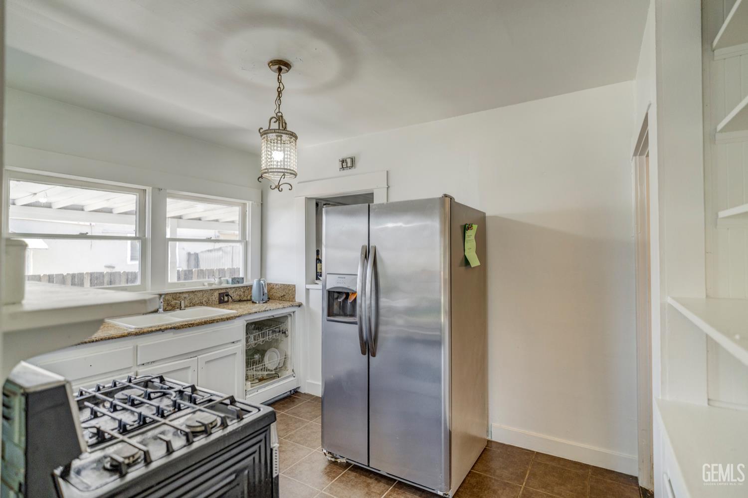 Undisclosed Address Bakersfield, CA 93304 - Photo 14 of 30 a kitchen with stainless steel appliances granite countertop a refrigerator a sink a stove and white cabinets