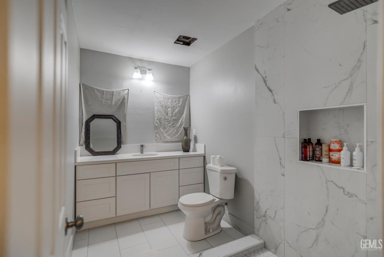 Undisclosed Address Bakersfield, CA 93304 - Photo 21 of 30 a bathroom with a toilet sink and mirror