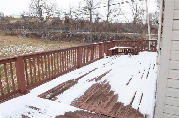 a view of a roof deck with wooden fence and trees