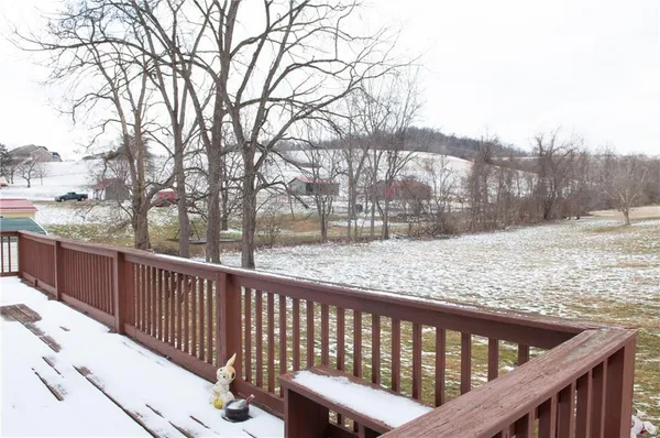 a view of a wooden roof deck with trees