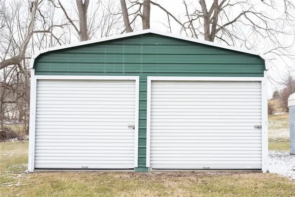 a small white house with a white roof and table and chairs