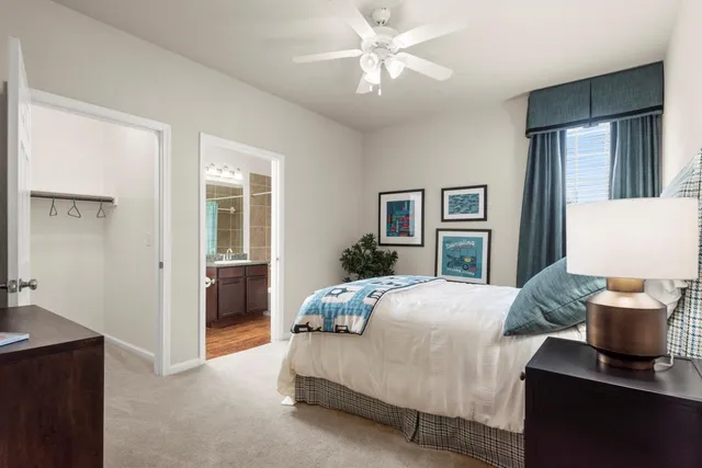 a bedroom with a large bed and a chandelier