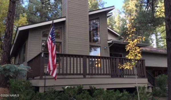 a view of a house with a small deck and a garden