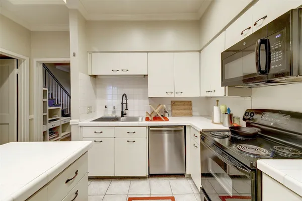 a kitchen with cabinets stainless steel appliances and wooden floor