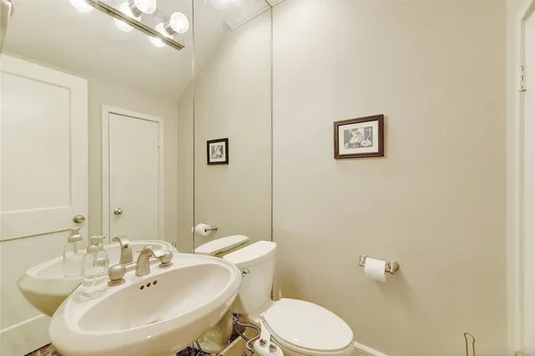 a bathroom with a sink mirror and toilet