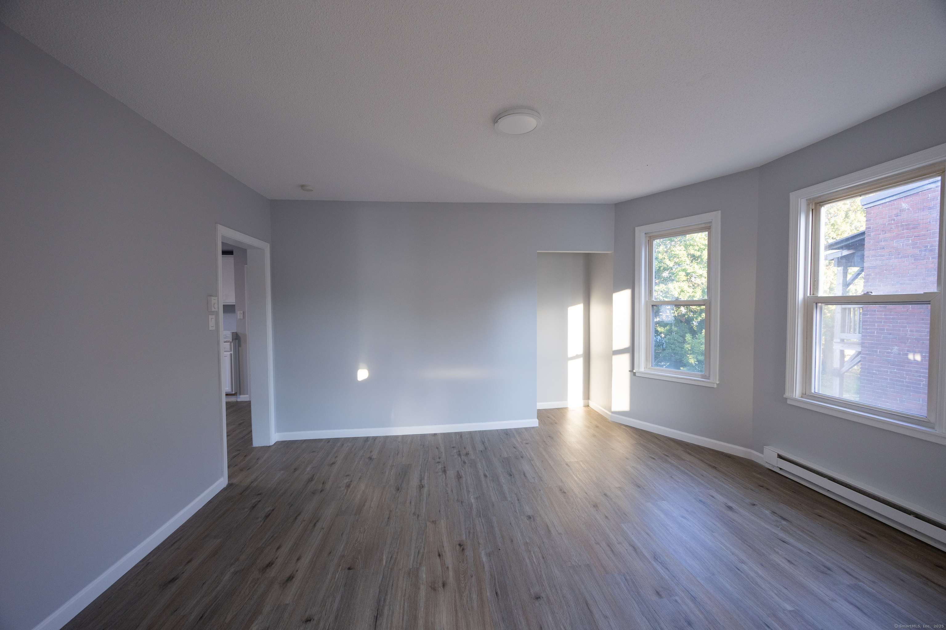 127 Lawlor Street New Britain, CT 06051 - Photo 2 of 9 an empty room with wooden floor and windows