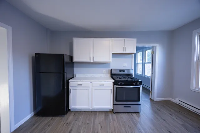 a kitchen with a refrigerator and a stove top oven
