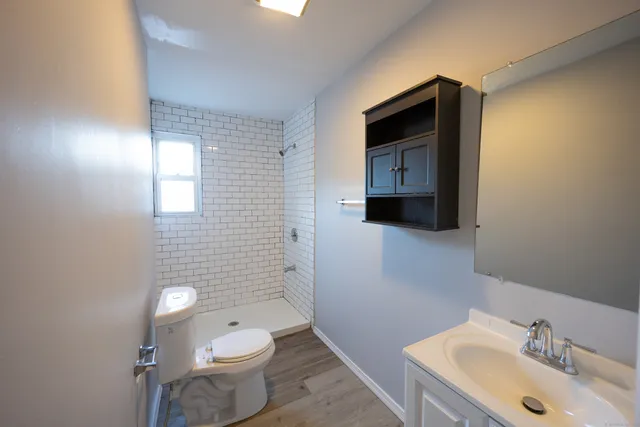 a bathroom with a toilet sink and mirror