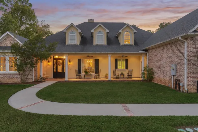 a view of a white house with a big yard and large trees