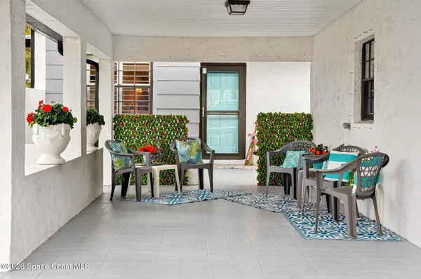 a dining room filled with furniture and a potted plant