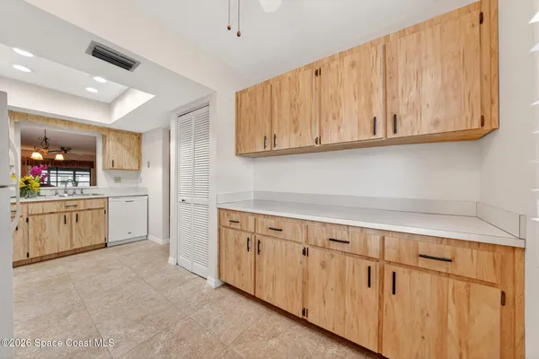 a kitchen with white cabinets and sink