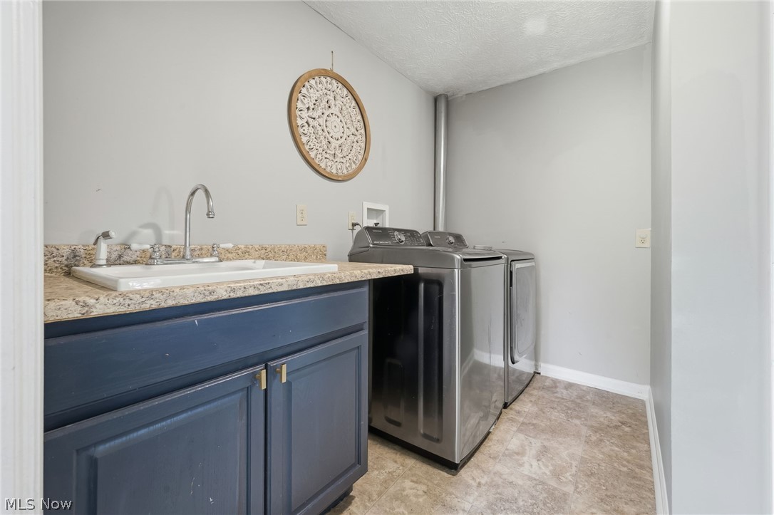 8160 Joyce Road Broadview Heights, OH 44147 - Photo 19 of 45 Laundry area featuring a utility sink, dark cabinetry, and light-toned countertops