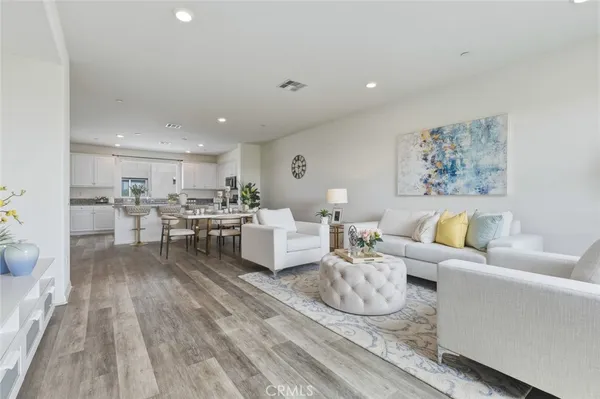a living room with furniture and view of kitchen