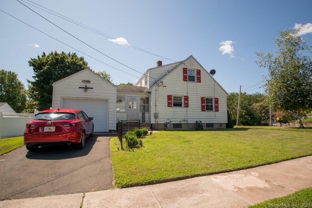 a front view of a house with a garden and parking