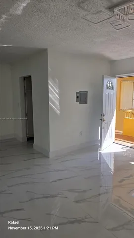 a view of hallway with wooden floor and a window
