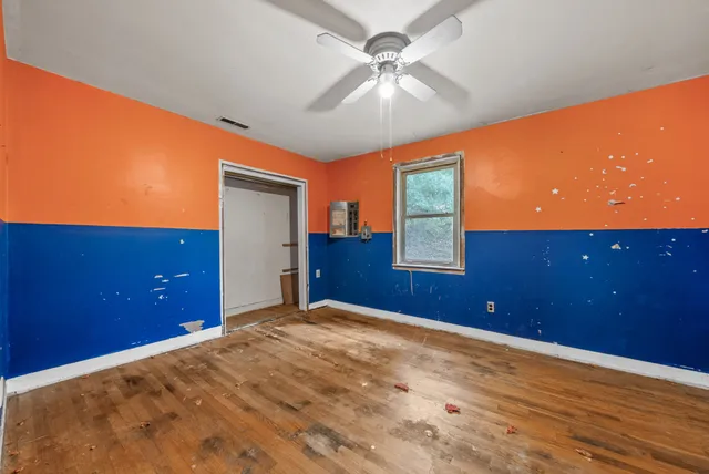 a bedroom with a bed and a ceiling fan