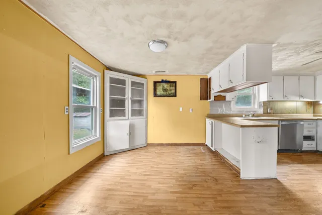 a kitchen with a refrigerator and wooden cabinets