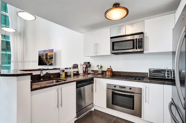 a kitchen with stainless steel appliances a stove a microwave a sink and cabinets