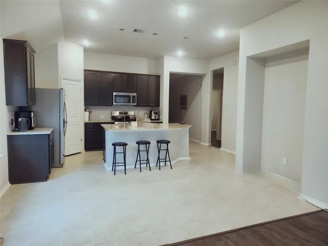 a large kitchen with a table and chairs