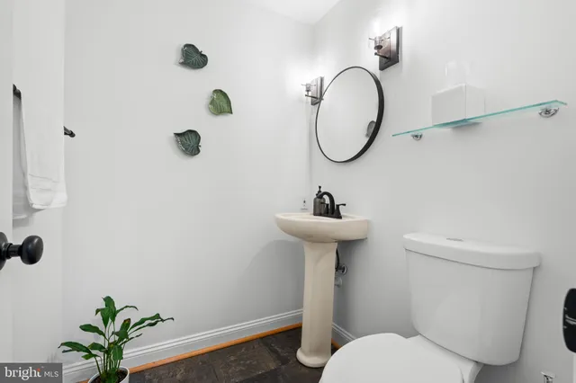 a bathroom with a toilet sink and mirror