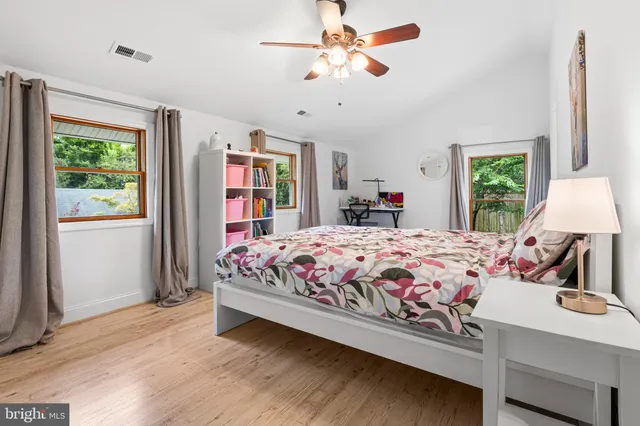 a bedroom with a large bed chandelier and a window