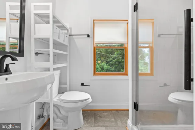 a bathroom with a toilet a sink and a window