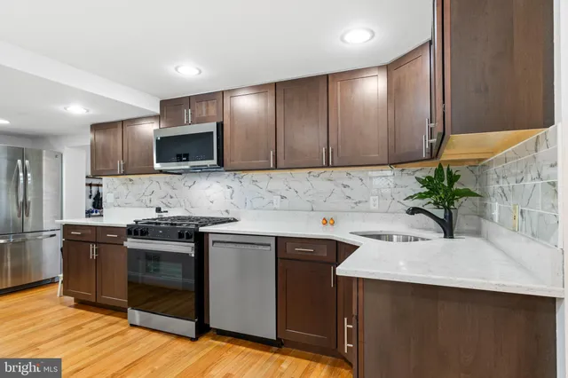 a kitchen with kitchen island granite countertop a sink stove and refrigerator