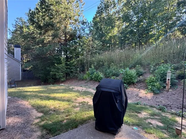 a view of a wooden house with a yard large tree and a wooden fence