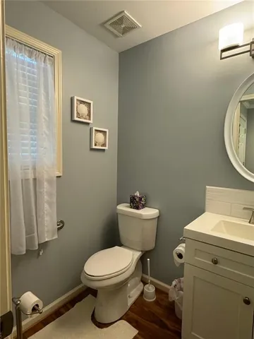 a bathroom with a toilet a sink and a mirror