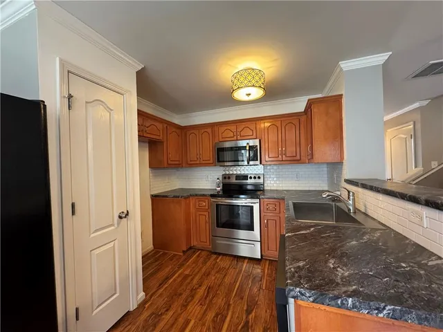a kitchen with stainless steel appliances granite countertop a refrigerator and a stove top oven