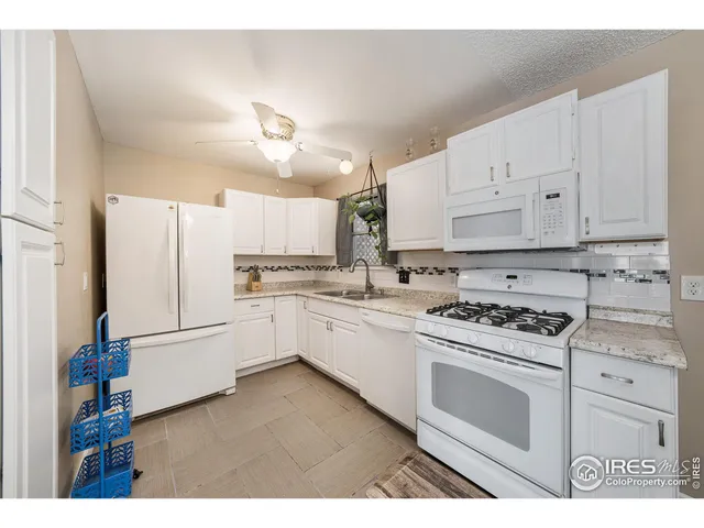 a kitchen with white cabinets and white appliances