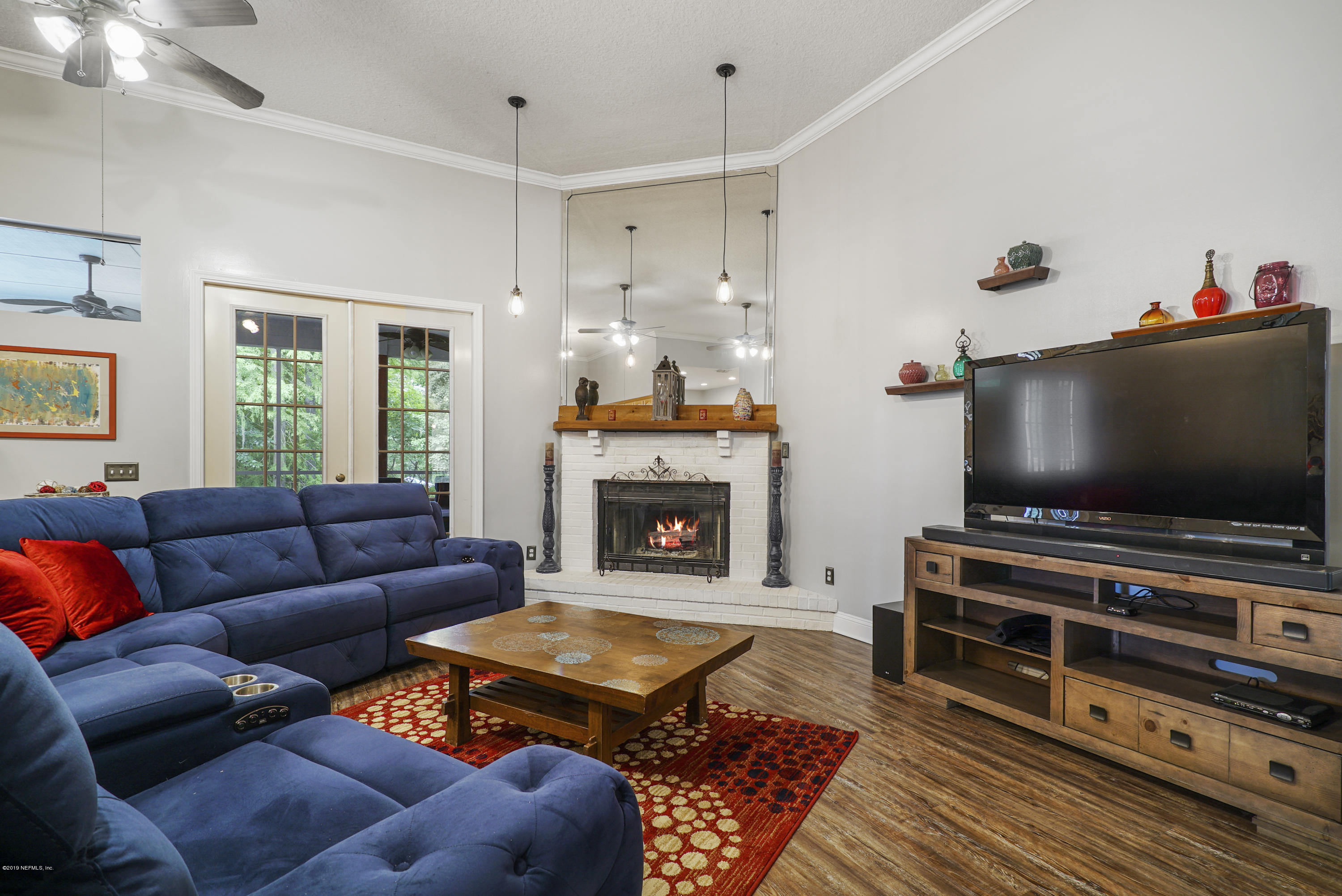 2066 Cornell Road Middleburg, FL 32068 - Photo 11 of 43 a living room with furniture a flat screen tv and a fireplace
