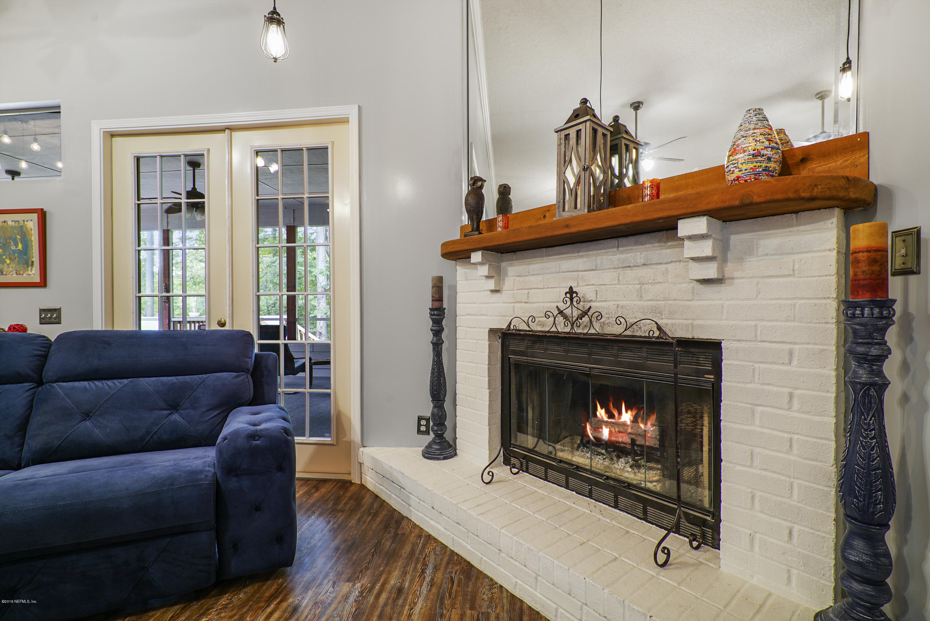 2066 Cornell Road Middleburg, FL 32068 - Photo 10 of 43 a living room with furniture a flat screen tv and a fireplace